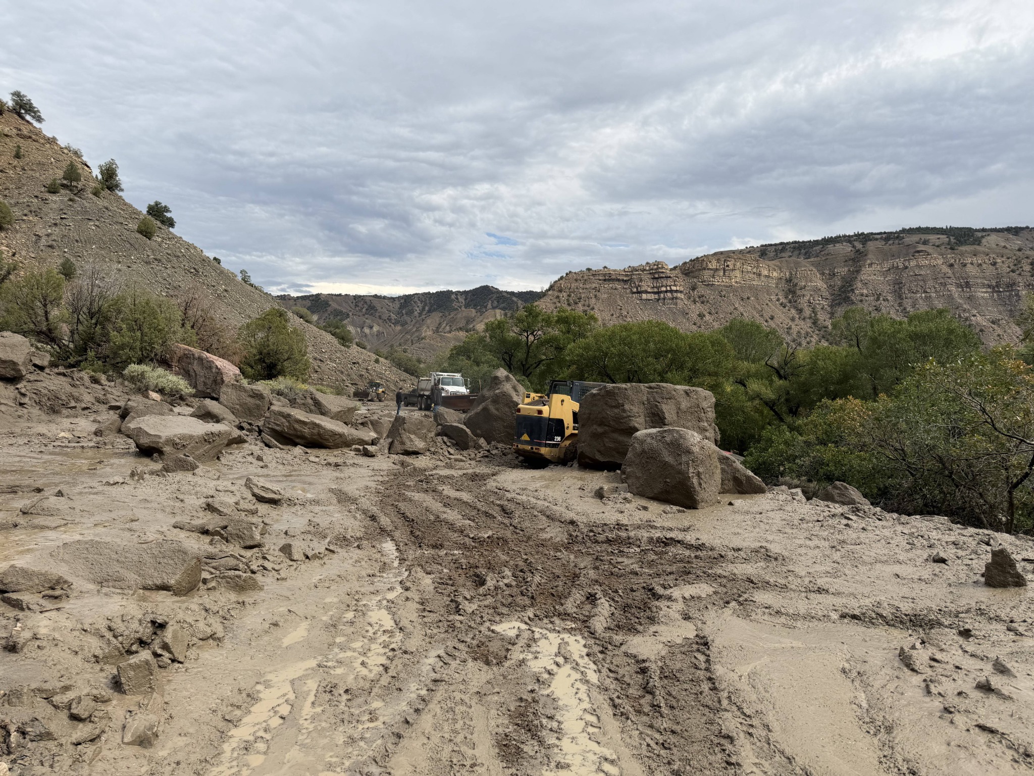 Road crews clear boulders and mud from Sweetwater Road after a rock slide